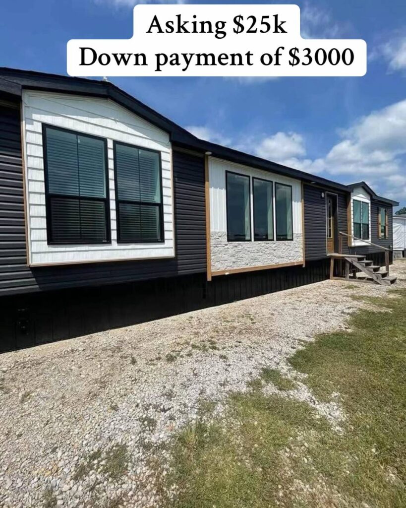 A mobile home under a blue sky, with dark siding and large windows. Text above reads "Asking $25k, Down payment of $3000." Calm and inviting scene.
