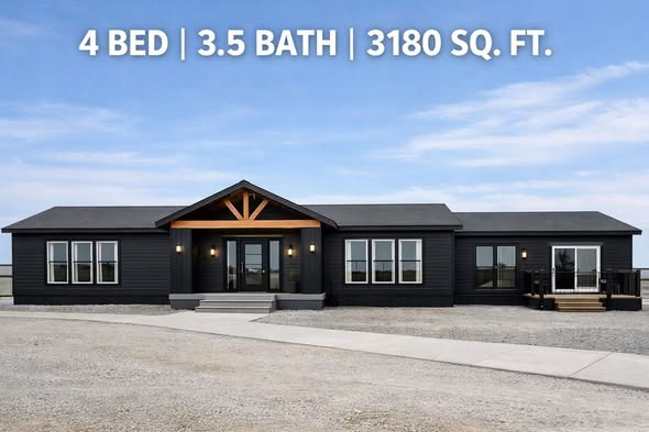 Modern black ranch-style home with a wooden entrance accent. Text reads "4 Bed | 3.5 Bath | 3180 Sq. Ft." against a bright blue sky backdrop.